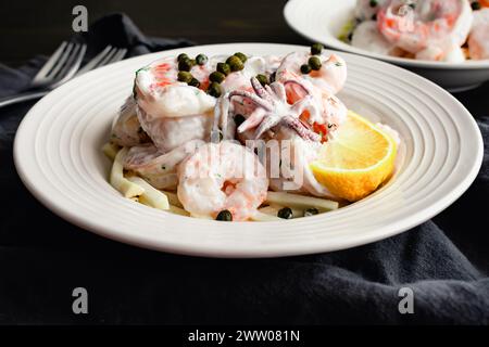 Poached Seafood Salad Served on Celery Root Remoulade Close-up: Shrimp, squid, and scallops with lemon dill sauce served over celeriac remoulade Stock Photo