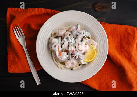 Poached Seafood Salad Served on Celery Root Remoulade: Bowl of shrimp, squid, and scallops with lemon dill sauce served over celeriac remoulade Stock Photo