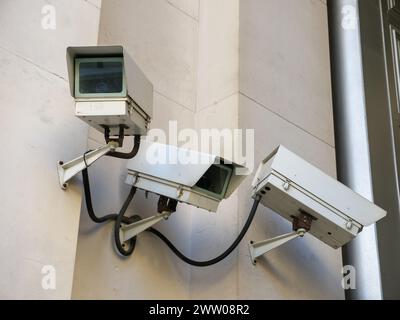 CCTV security cameras keeping watch outside building, UK Stock Photo
