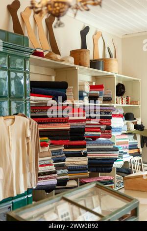 Vintage clothing and fabric store. A full shelf of colorful goods. Vertical photo. Stock Photo