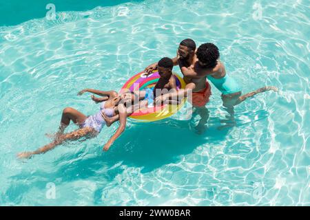An African American family enjoys a sunny day in the pool Stock Photo
