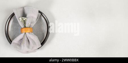 Easter banner. Gray plates and gray napkin on gray textured background. Top view, flat lay. Stylish table setting for cafe and restaurant. Copy space Stock Photo