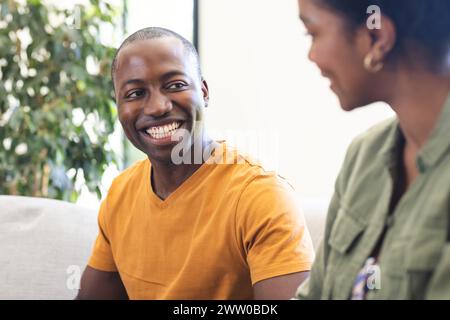 Happy young african american husband helps to wife in sportswear do ...