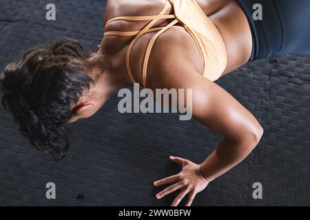 A fit Caucasian woman is doing push-ups in the gym Stock Photo