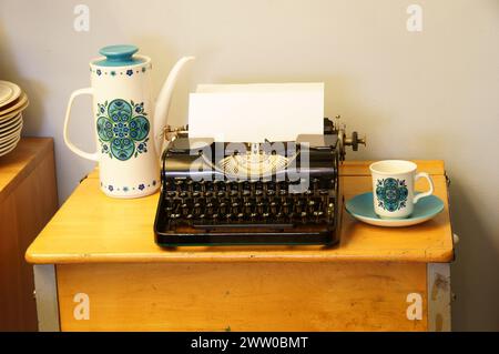 Graphic art and photography for writers of a retro typewriter, vintage coffee pots, tea pots and tea cups. Stock Photo