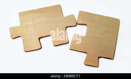 Fitting wooden puzzle pieces isolated on a white background. Concept of business solution, solving a problem. Stock Photo