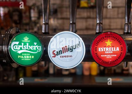 Beer Lager pump clips badges on a beer font engine in a pub in Newquay in Cornwall in the UK. Stock Photo