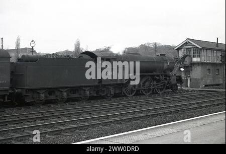 1950s, historical, a British Railways steam locomotive, 60842 on rail track with full coal wagon at Welwyn Garden City train station, England, UK, showing signal box. The Gresley V2 Class was introduced in 1936, with the 60842 introduced in 1938 to perform passenger and mixed traffic trains for LNER. The locomotive was transfered to the new British Railways in 1950, being withdrawn in 1962. Stock Photo