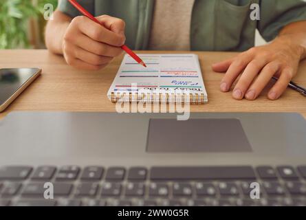 Man in office writes goals, plans, make to do and wish list in small notebook. Stock Photo