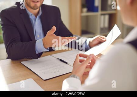 Two company employees sitting in office looking through documents on workplace. Stock Photo