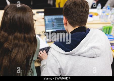 Software developer students in auditorium hall working on computer and laptop, programming contest hackathon competition, pc with coding program app, Stock Photo