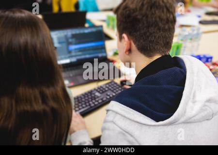Software developer students in auditorium hall working on computer and laptop, programming contest hackathon competition, pc with coding program app, Stock Photo