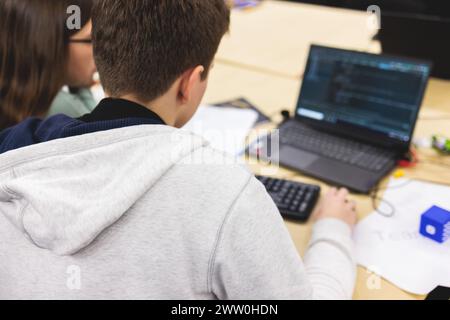 Software developer students in auditorium hall working on computer and laptop, programming contest hackathon competition, pc with coding program app, Stock Photo