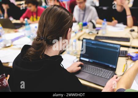 Software developer students in auditorium hall working on computer and laptop, programming contest hackathon competition, pc with coding program app, Stock Photo