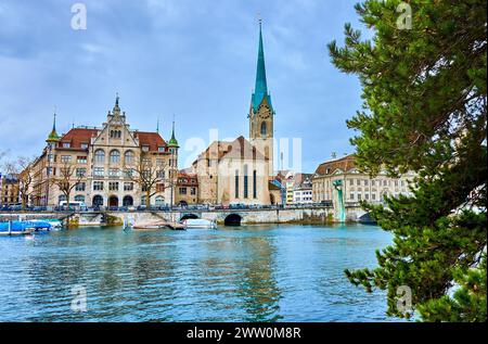 Fraumunster church seen through the pine tree branches presents a serene and enchanting view in Zurich, Switzerland. Stock Photo