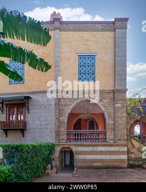 A serene view of a rustic style building featuring an arched wooden balcony, and detailed window grills Stock Photo