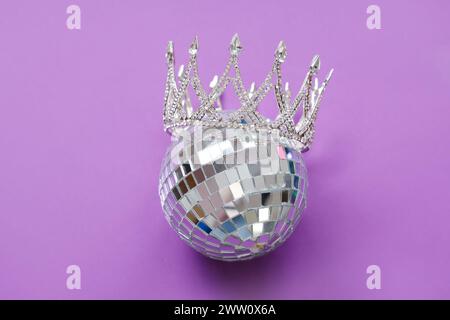 Disco ball with prom crown on purple background Stock Photo