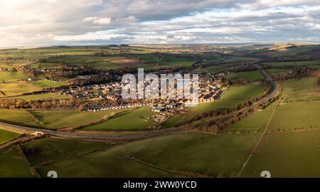 An aerial panoramic landscape of the village of Haydon Bridge in the Northumberland National Park with the River Tyne running through and A69 road byp Stock Photo