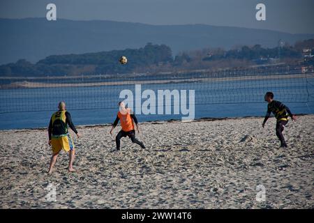 Vigo, Pontevedra, Spain; January,18,2022; On Playa del Vao a group of friends play a game of soccer tennis on a sunny day in January Stock Photo
