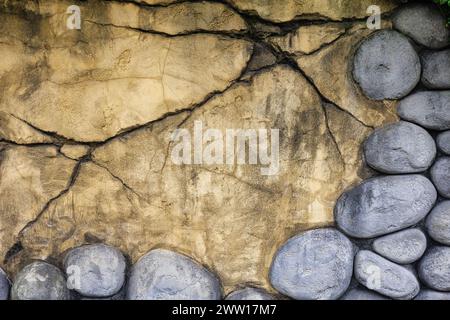 Weathered Yellow Concrete Wall with Pebble Frame: Texture and Cracks, Germany, Bruehl, Fantasialand Stock Photo
