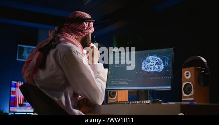 Developer typing on keyboard, updating artificial intelligence neural networks, writing complex binary code scripts. Muslim freelance programmer in personal office upgrading high tech AI Stock Photo