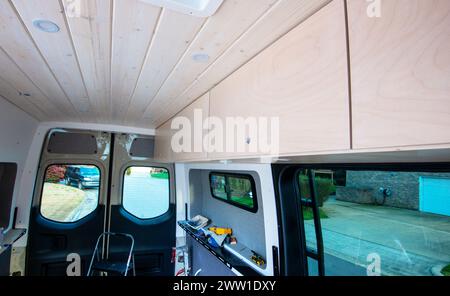 Tongue and groove 1x6 and diy upper cabinets built for  Mercedes Benz sprinter cargo van conversion to mobil home. Cary, North Carolina, Stock Photo