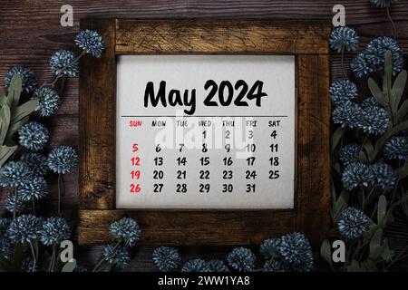 May 2024 monthly calendar with flower bouquet decoration  on wooden background Stock Photo