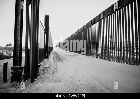 The US border wall between Yuma Arizona and Los Algodones Mexico.  Black and white image. Stock Photo