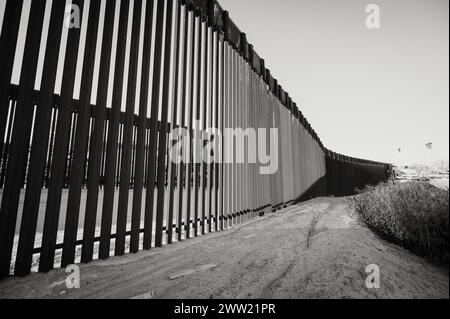 The US border wall between Yuma Arizona and Los Algodones Mexico.  Black and white image. Stock Photo