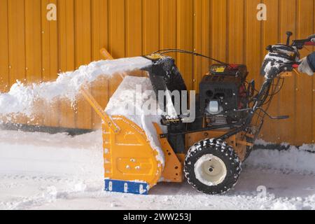 Snow blower effectively removes snow that accumulated on city streets after winter snowstorm. Its powerful mechanism throws snow off streets Stock Photo