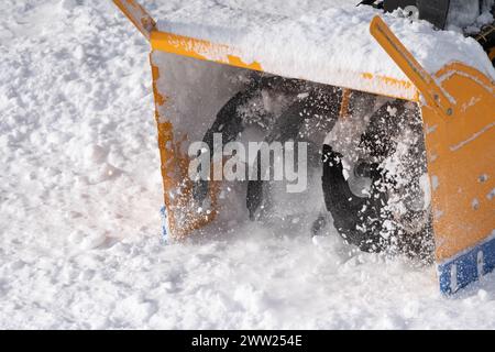 Snow blower machine mechanism is expertly shown in extreme close-up throwing snow off road after snowy blizzard. Is perfect tool for removing snow Stock Photo