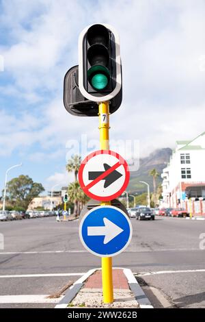 Road sign, traffic light and signage in street for direction with attention notification and arrow symbol outdoor in city. Board, public notice and Stock Photo