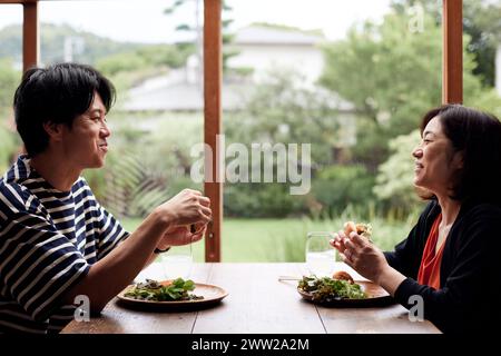 A man and a woman sitting at a table eating Stock Photo