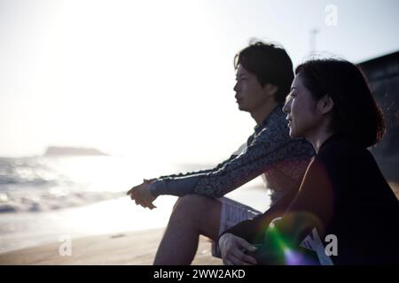 A man and woman sitting on the beach Stock Photo
