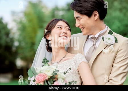 Asian bride and groom smiling at each other Stock Photo