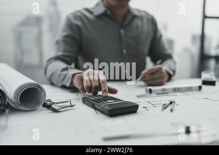 Engineering working with drawings inspection and press calculator on Blueprint. Engineer, Architect, Industry and factory concept. Stock Photo