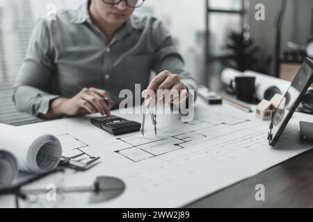 Architect using divider compass working on blueprint.  House planning design and construction concept. Stock Photo