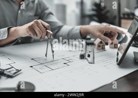 Architect using divider compass working on blueprint.  House planning design and construction concept. Stock Photo