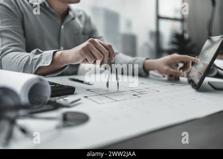 Architect using divider compass working on blueprint.  House planning design and construction concept. Stock Photo
