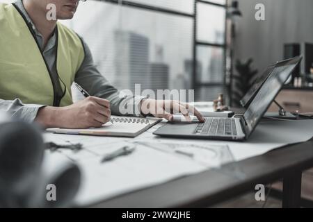 Engineering working with laptop inspection on the office desk. Engineer, Architect, Industry and factory concept. Stock Photo