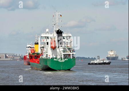 Large green container ship sailing supported by a tugboat in the harbour, Hamburg, Hanseatic City of Hamburg, Germany Stock Photo