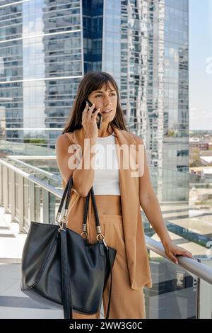 A serious businesswoman is talking on her cell phone outdoors Stock Photo