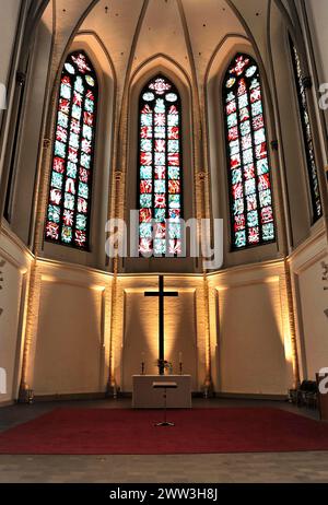 Sankt-Petri-Kirche, parish church, construction started in 1310, Moenckebergstrasse, church altar with illuminated stained glass windows and cross in Stock Photo