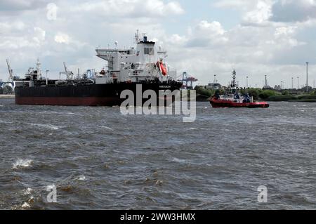 A tanker and a tugboat in the turbulent waters of a harbour, Hamburg, Hanseatic City of Hamburg, Germany Stock Photo