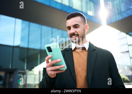 A young Caucasian man in a formal suit standing in front outside an office building Stock Photo