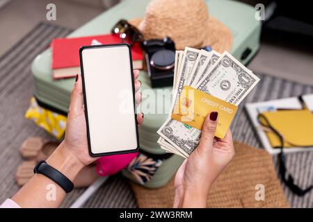 The mobile phone, banknotes, and a travel wallet are prepared to embark on a journey for tourism Stock Photo