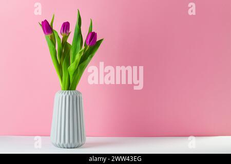 boquet of tulip on a peach color background standing in a vase Stock Photo