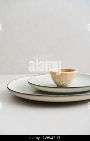 Two plates of different sizes and tiny bowl on light backgrount Stock Photo