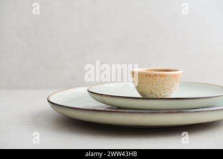 Two plates of different sizes and tiny bowl on light background Stock Photo