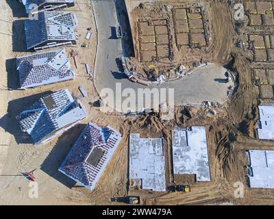 New construction of single family homes being built along a cul-de-sac is shown from an overhead, aerial view during the day. Stock Photo